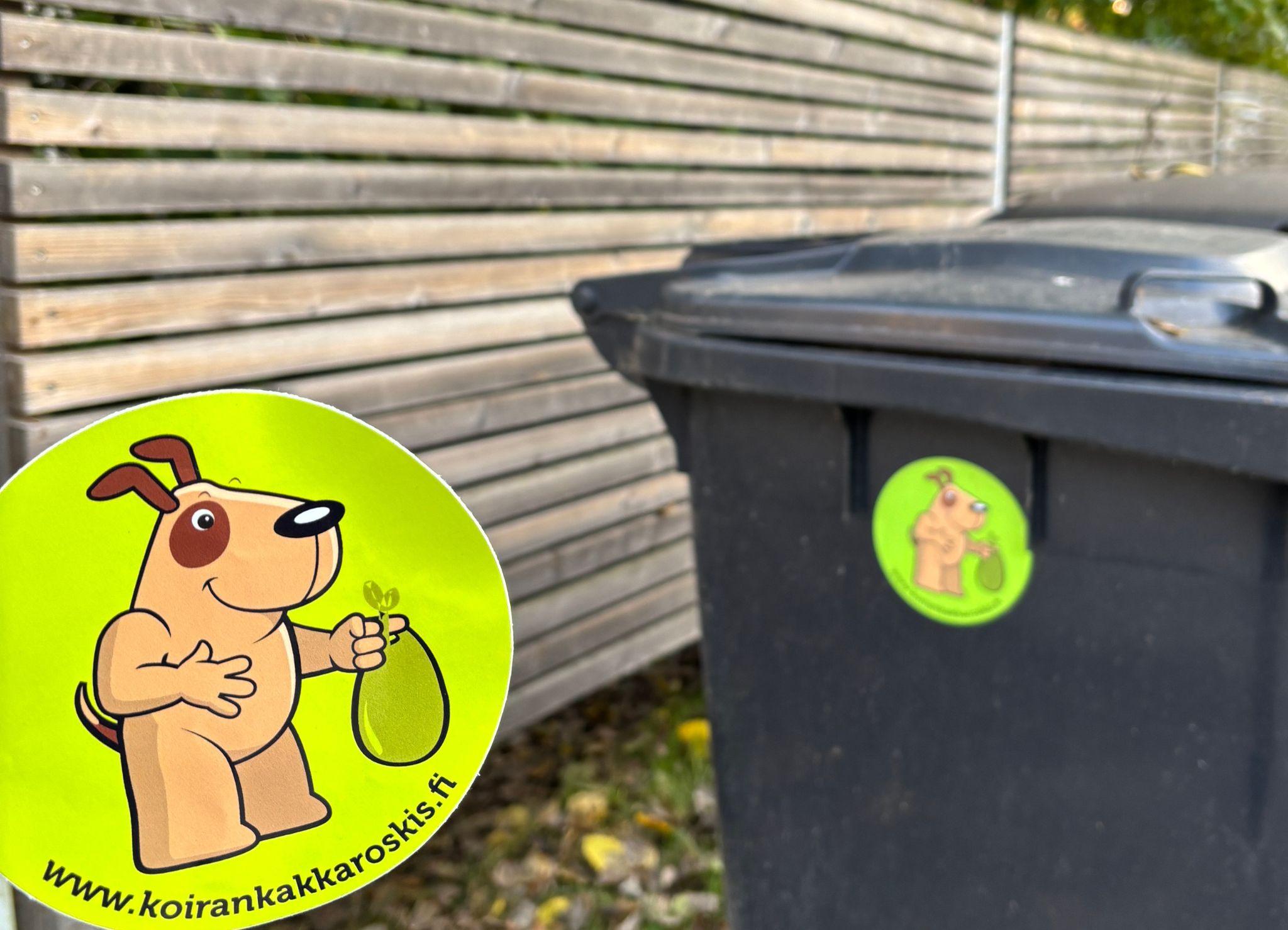 Koirankakkaroskis -tarra jäteastiassa kiinni.